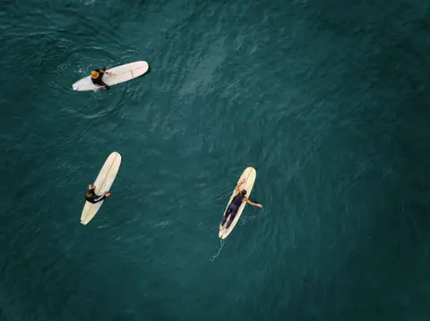 Three longboards on deep blue water from above